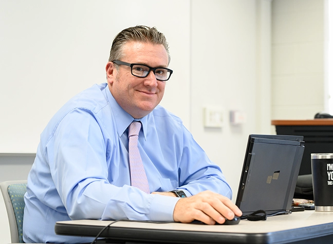 Man with laptop in classroom