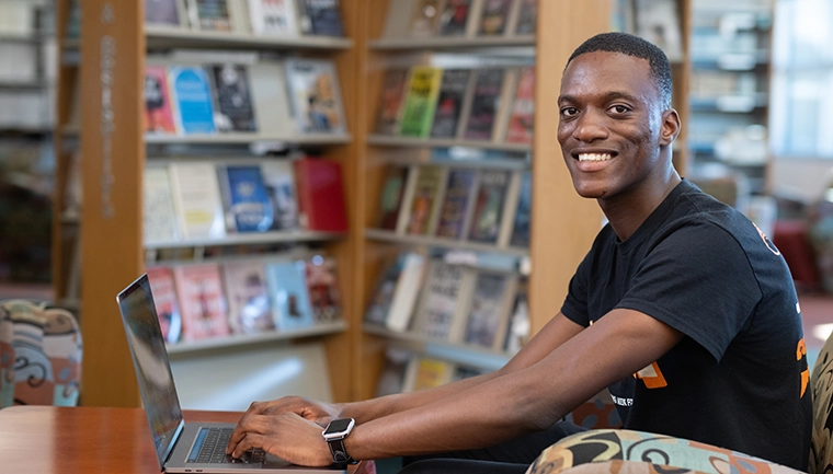 Male student in library with books