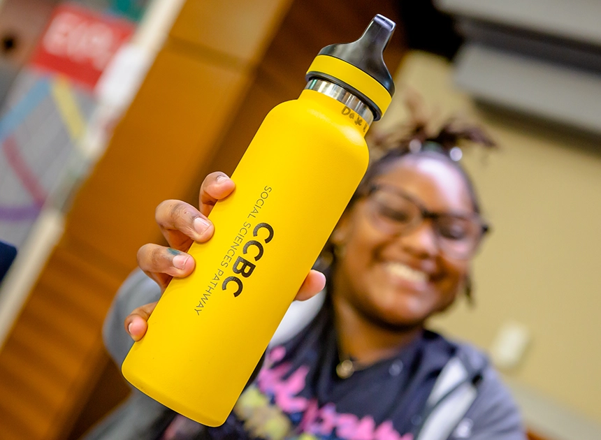 Vote CCBC Best Community College happy student holding a CCBC reusable water bottle
